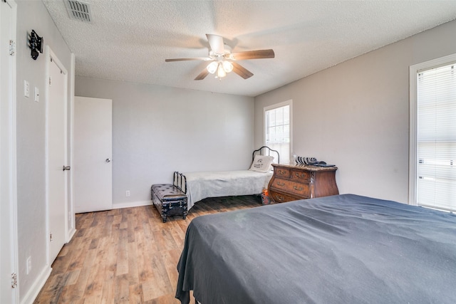 14357 Fm 1392, Terrell, TX 75160 - bedroom with wood finished floors, visible vents, a ceiling fan, baseboards, and a textured ceiling