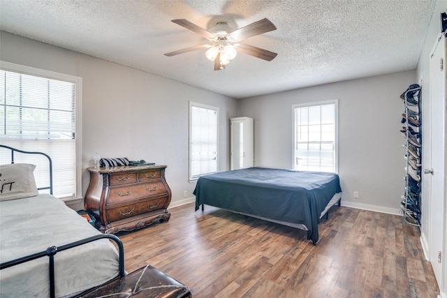14357 Fm 1392, Terrell, TX 75160 - bedroom with wood finished floors, a textured ceiling, baseboards, and multiple windows