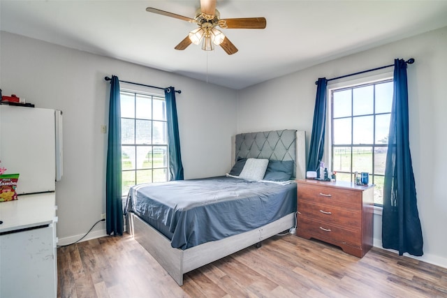 14357 Fm 1392, Terrell, TX 75160 - bedroom featuring freestanding refrigerator, light wood-type flooring, baseboards, and ceiling fan