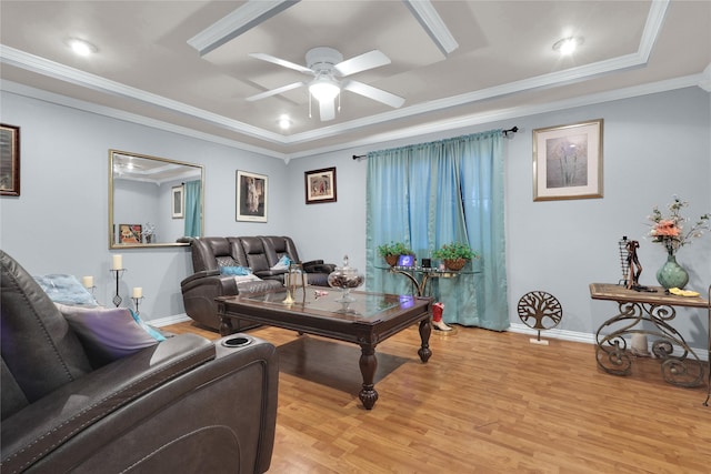 living area featuring light wood finished floors, ornamental molding, baseboards, and ceiling fan