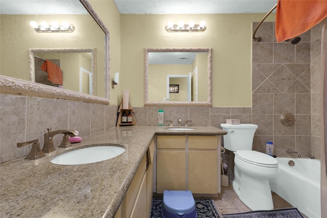 bathroom featuring tile patterned floors, backsplash, vanity, tile walls, and shower / tub combination