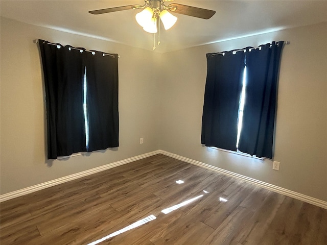 empty room with ceiling fan, baseboards, and wood finished floors