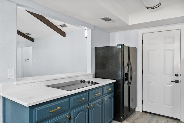 kitchen featuring blue cabinets, black appliances, beamed ceiling, light wood-style flooring, and a peninsula