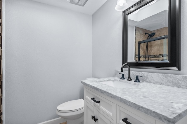 bathroom featuring baseboards, visible vents, toilet, and vanity