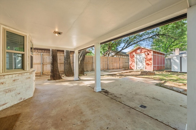 view of patio / terrace featuring a fenced backyard, a storage unit, and an outdoor structure