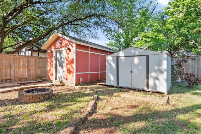 view of shed featuring a fenced backyard and an outdoor fire pit
