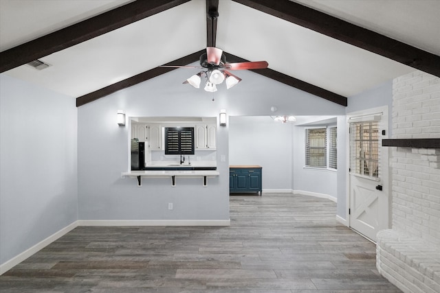 unfurnished living room with baseboards, wood finished floors, visible vents, and ceiling fan