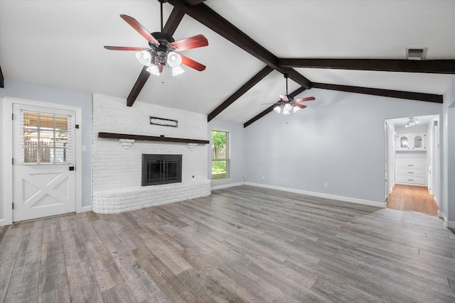 unfurnished living room with lofted ceiling with beams, wood finished floors, visible vents, and ceiling fan