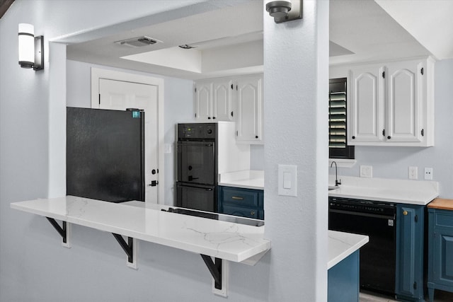 kitchen with visible vents, a kitchen bar, blue cabinetry, and black appliances