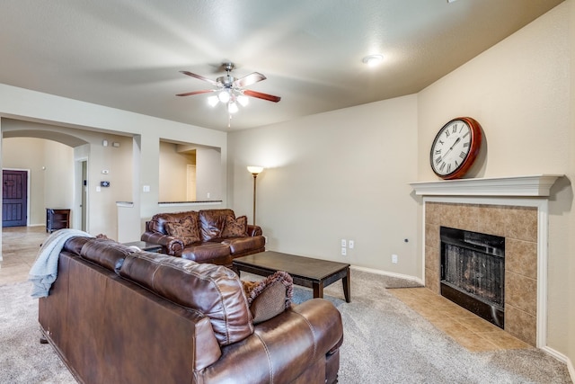 10625 Sexton Dr, Mckinney, TX 75072 - living area with light colored carpet, arched walkways, a ceiling fan, and a tiled fireplace
