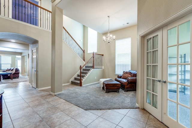 10625 Sexton Dr, Mckinney, TX 75072 - foyer with light carpet, arched walkways, light tile patterned floors, a chandelier, and stairs