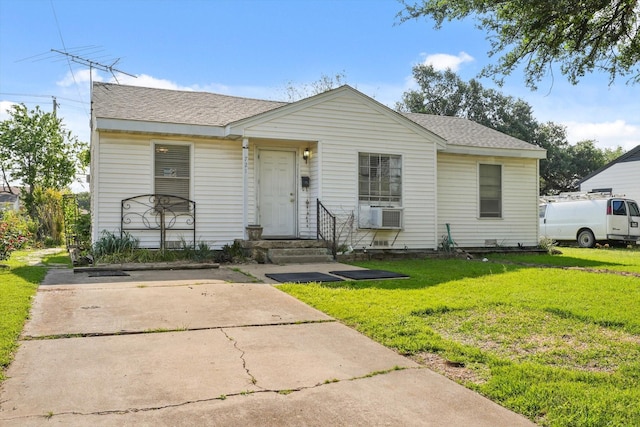 bungalow-style home with roof with shingles and a front lawn