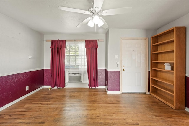 spare room featuring wood finished floors, baseboards, and a ceiling fan
