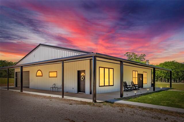 exterior space with a lawn, a detached garage, and dirt driveway