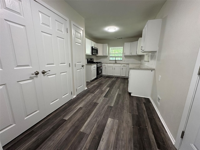 1928 Las Cruces Ln, Dallas, TX 75217 - kitchen featuring white cabinets, stainless steel appliances, baseboards, and dark wood-style flooring