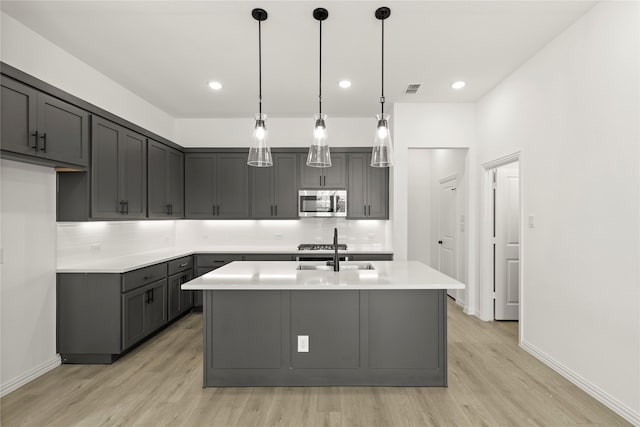 913 Janwood Dr, Plano, TX 75075 - kitchen with stainless steel microwave, light wood finished floors, tasteful backsplash, light countertops, and recessed lighting