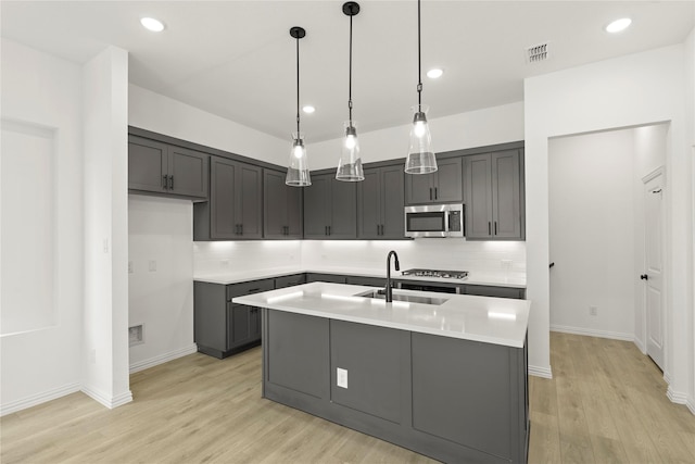 913 Janwood Dr, Plano, TX 75075 - kitchen with stainless steel appliances, backsplash, light wood-style flooring, light countertops, and hanging light fixtures
