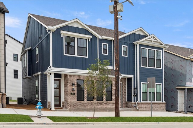 913 Janwood Dr, Plano, TX 75075 - view of front facade featuring board and batten siding, cooling unit, and brick siding