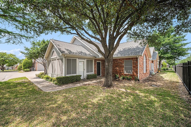 6132 Haley Ln, Fort Worth, TX 76132 - view of front facade featuring brick siding, fence, a shingled roof, and a front yard
