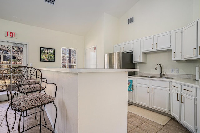 6132 Haley Ln, Fort Worth, TX 76132 - kitchen with a sink, visible vents, white cabinetry, light countertops, and high vaulted ceiling