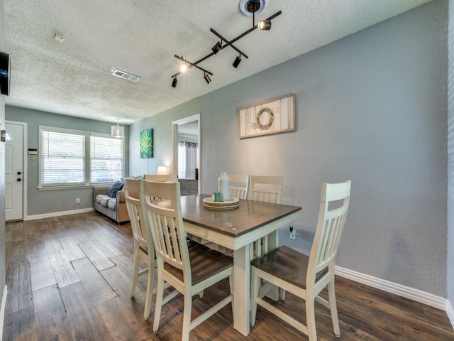 2631 Greenhurst Dr, Farmers Branch, TX 75234 - dining room featuring a textured ceiling, wood finished floors, and baseboards