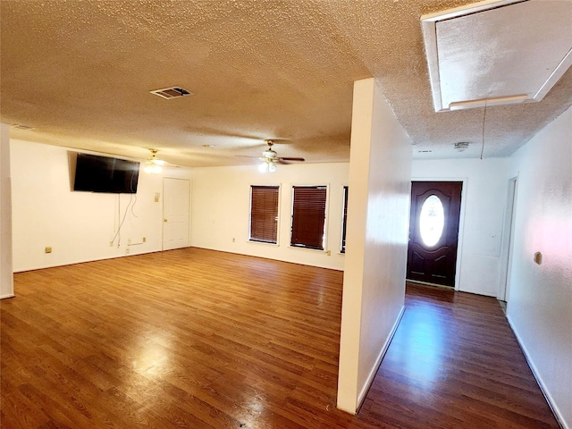 entryway with wood finished floors, visible vents, baseboards, a textured ceiling, and ceiling fan