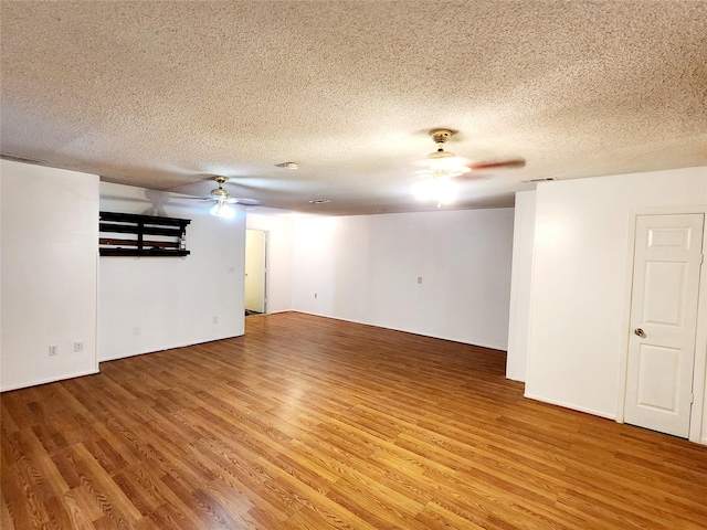 unfurnished room featuring a ceiling fan, a textured ceiling, and light wood-type flooring