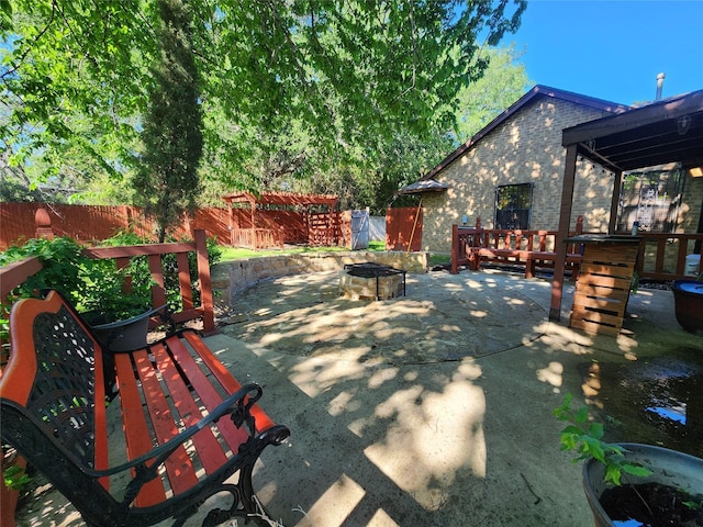 view of patio with a fenced backyard and a fire pit