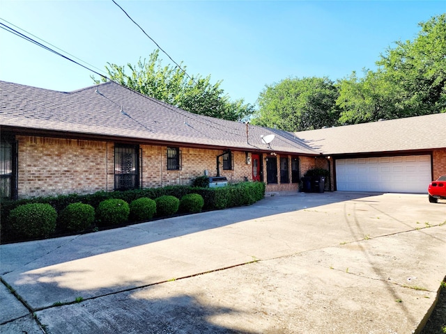 ranch-style home with brick siding, concrete driveway, and a garage