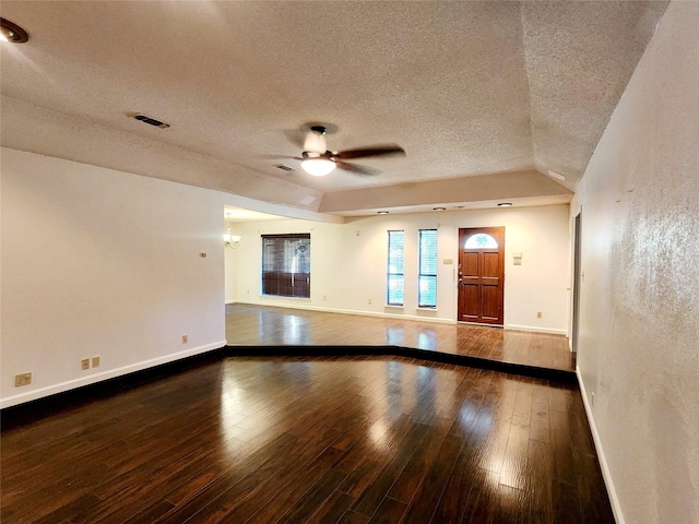 spare room featuring a textured ceiling, visible vents, baseboards, a ceiling fan, and hardwood / wood-style flooring