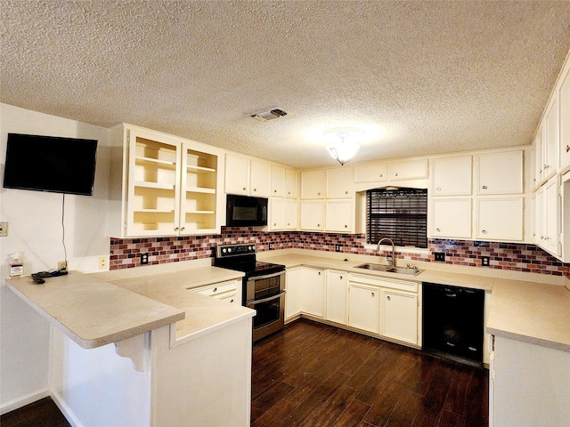 kitchen featuring backsplash, a sink, black appliances, a peninsula, and dark wood-style flooring