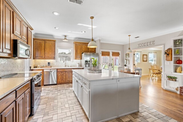 kitchen featuring brown cabinetry, visible vents, backsplash, and appliances with stainless steel finishes