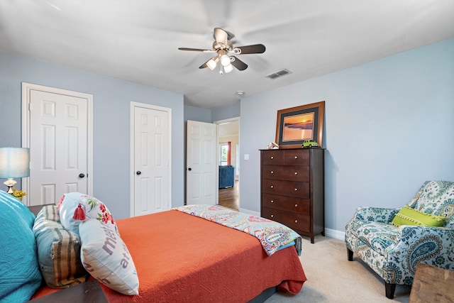 bedroom with ceiling fan, baseboards, visible vents, and light colored carpet
