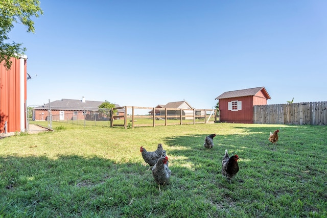 view of yard featuring a fenced backyard, an outdoor structure, and a shed