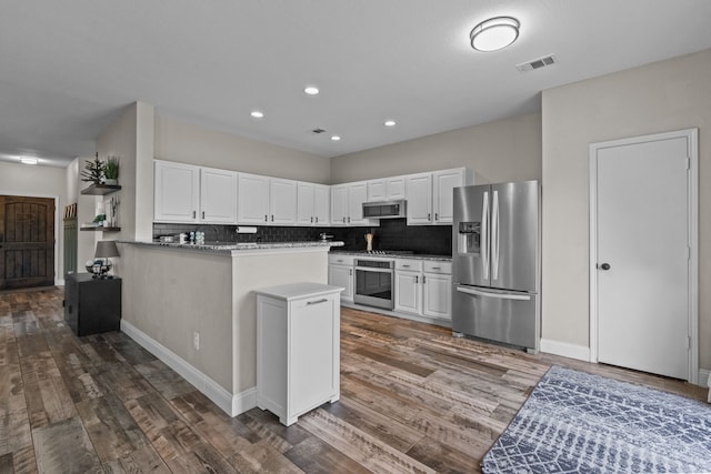 9112 Manassas Rdg, Mckinney, TX 75071 - kitchen with appliances with stainless steel finishes, tasteful backsplash, wood finished floors, white cabinetry, and recessed lighting
