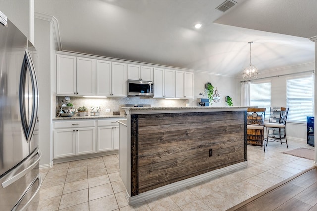 kitchen with white cabinets, ornamental molding, stainless steel appliances, and visible vents