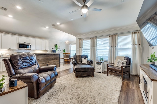 living room featuring dark wood-type flooring, vaulted ceiling, and plenty of natural light