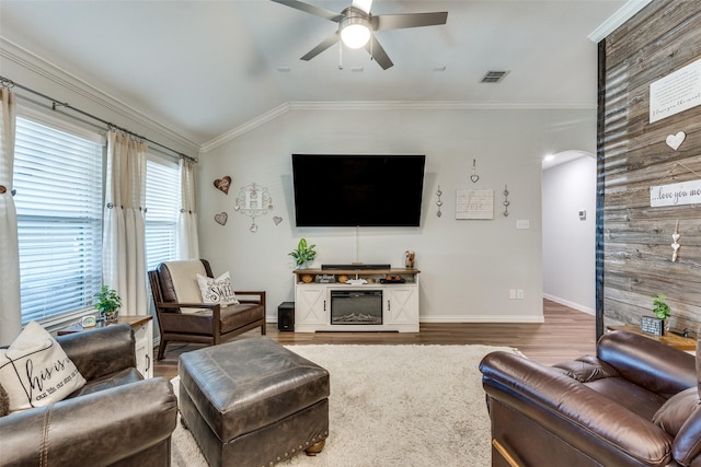 living room featuring arched walkways, baseboards, visible vents, a ceiling fan, and wood finished floors