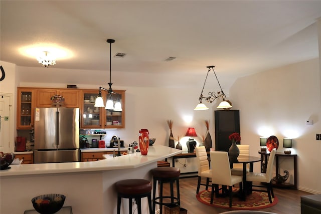103 Sunglow Loop, Red Oak, TX 75154 - kitchen featuring light countertops, visible vents, freestanding refrigerator, glass insert cabinets, and a breakfast bar area