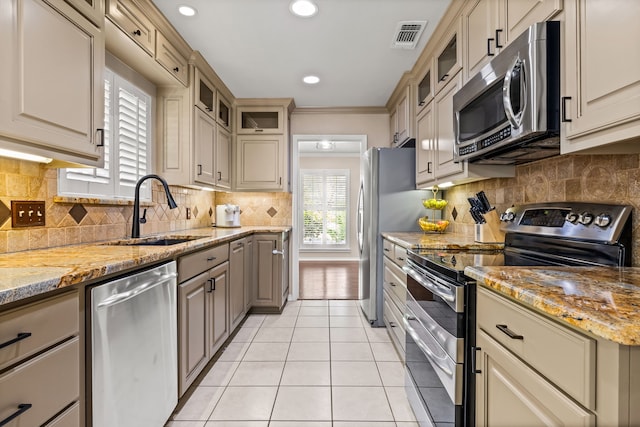 kitchen with visible vents, light tile patterned floors, a sink, decorative backsplash, and appliances with stainless steel finishes