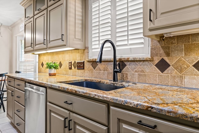 kitchen featuring dishwasher, tasteful backsplash, light stone countertops, and a sink