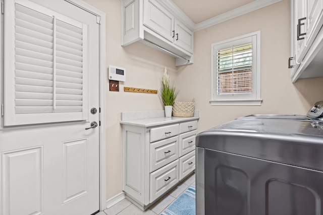 washroom with washing machine and clothes dryer, light tile patterned floors, crown molding, and cabinet space