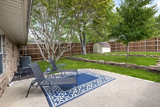 view of patio / terrace with a storage unit, an outbuilding, central AC, and a fenced backyard