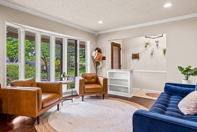 living room featuring a textured ceiling, baseboards, recessed lighting, wood finished floors, and crown molding