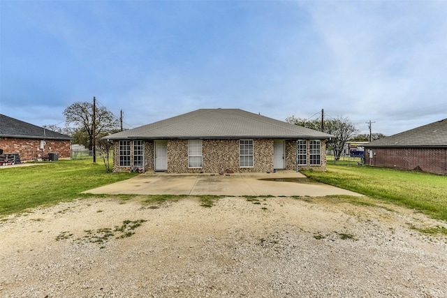 2545 E Renfro St, Burleson, TX 76028 - rear view of house with a lawn, brick siding, and a patio area