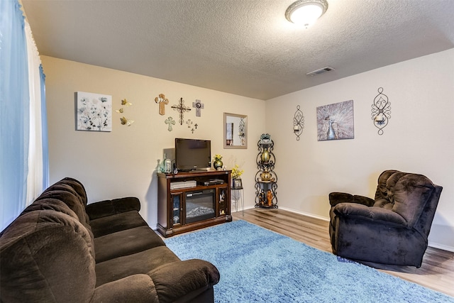 2545 E Renfro St, Burleson, TX 76028 - living room with baseboards, wood finished floors, visible vents, and a textured ceiling