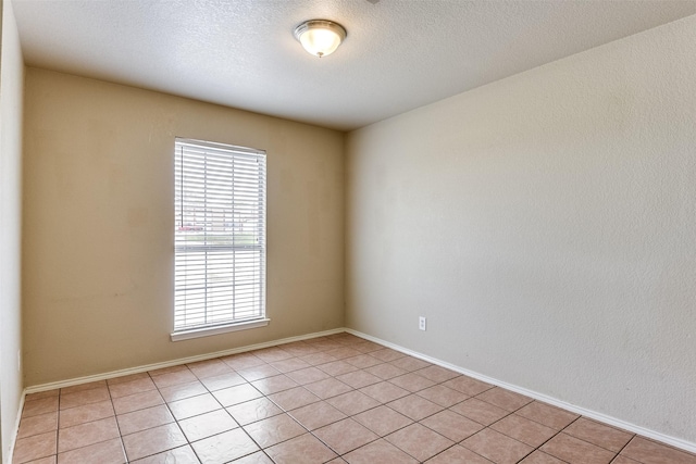 2545 E Renfro St, Burleson, TX 76028 - empty room with light tile patterned flooring, a textured ceiling, and baseboards