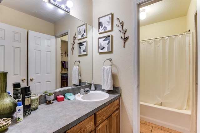 2545 E Renfro St, Burleson, TX 76028 - full bathroom with tile patterned flooring, shower / tub combo, a textured wall, and vanity