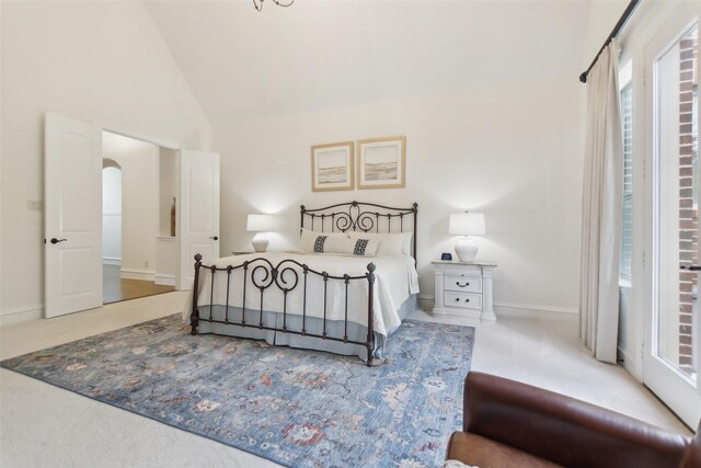 bedroom with baseboards, arched walkways, carpet flooring, and vaulted ceiling