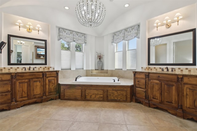 bathroom featuring lofted ceiling, a garden tub, a notable chandelier, and a sink